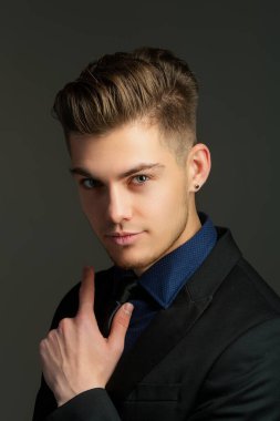 Takım elbiseli yakışıklı adamın portresi. Genç adam manken portresi. Erkek yüzü. Genç yakışıklı adam. Kendine güvenen erkek model. Adam gururlu görünüyor. Çekici bir adamın yakın çekim yüzü. Zarif adam.