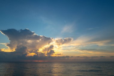 Gün batımı denizi. Bulutların arasından gün batımını izleyen sakin bir deniz. Meditasyon okyanusu ve gökyüzü arka planı. Huzurlu deniz manzarası. Günbatımı deniz suyunun üzerinde bir ufuk. Gün batımı gökyüzü sakin