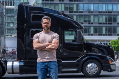 Kamyon şoförü. CDL. Kamyon aracının yanında nakledilmeye hazır duran kamyoncu portresi. Kamyonun önünde duran bir erkek sürücü.