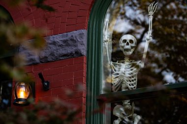 Şükran Günü Tatili. Cadılar Bayramı balkabağı ve dekore edilmiş ev için iskelet. Evin ön bahçesindeki korkunç dekorasyonlar. Şeker mi şaka mı? Cadılar Bayramı geçmişi. Cadılar Bayramı ve Şükran Günü