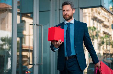 Şehirde alışveriş yapan yakışıklı bir adam. Takım elbiseli bir işadamının portresi.