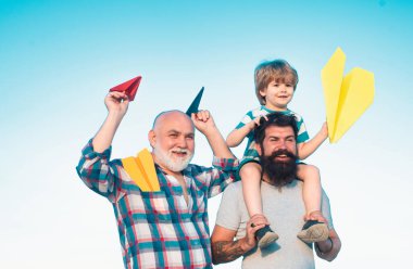 Dedemin oğlu ve torunu parkta eğleniyor. Babalar Günü - Büyükbaba, baba ve oğul kucaklaşıyor ve birlikte eğleniyorlar.