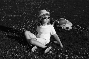 Doğadaki çocuk. Çocukların rahatlaması. Çocuk parkta bir yürüyüşe çıkar. Yaz tatili aktivitesi. Ufaklık dışarıda dinleniyor. Bahçede oynayan çocuk