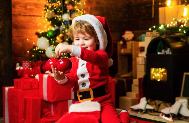 Kış tatili için şöminede hediyeler. Noel hediyeli küçük çocuk. Neşe ve mutluluk. Çocukluk anları. Neşeli çocuk Noel 'de hediye aldı. Yılbaşı çorabının içeriğini kontrol et