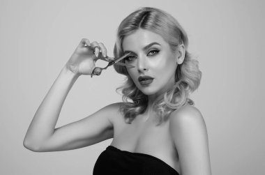 Woman with scissors in studio. Elegant woman from hairdressers salon. Girl with straight hair with professional scissor. Haircare concept. Hairdresser scissors, haircut accessories