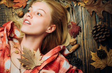 Güzel şehvetli sarışın yaprakları ile oynuyor. Sonbahar yaprakları ile arka plan. Mutlu genç kadın sonbahar güneşli gün için hazırlanıyor. Yapraklarla oynayan sürpriz kadın. Güzel şehvetli sarışın