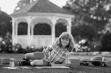 Parkta resim çizen küçük bir sanatçı. Çocuk sanatçısı, çocuk işçiliği. Okul çocukları yaz parkında resim çiziyor, resim yapıyor. Küçük ressam açık havada resimler çizer.