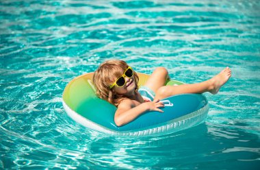 Yaz tatili. Yaz çocukları hafta sonu. Yüzme havuzunda bir çocuk. Aquapark 'ta şişme lastik çemberde komik çocuk.