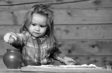 Erkek bebek mutfakta yemek pişiriyor, yumurtalarla oynuyor. Yumurtaları kıracak çocuk.