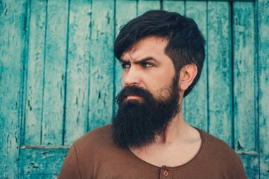 Yakışıklı adamın portresi. Hippi bir modelin vesikalık fotoğrafı. Erkek yüzü. Sakallı yakışıklı adam. Kendine güvenen erkek model. Adam gururlu görünüyor. Çekici bir adamın yakın çekim yüzü. Sakal ve bıyık.