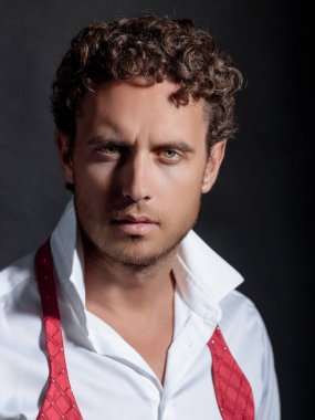 Tıraşsız, gömlekli ve fiyonklu seksi bir adam. Yakışıklı adamın portresi. Hippi bir modelin vesikalık fotoğrafı. Erkek yüzü. Genç yakışıklı adam. Kendine güvenen erkek model. Adam gururlu görünüyor