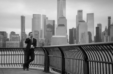 New York 'ta iş. Açık havada akıllı telefon kullanan bir iş adamı. Takım elbiseli bir iş adamı, Manhattan, New York 'taki uygulamalı mesajla cep telefonu kullanıyor. İş konuşmaları. Akıllı telefonlu bir iş adamı.