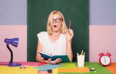 Beyaz kadın öğretmen ya da öğrencinin portresi. Derste neşeli bir öğretmen. Öğretmenlik, ciddi bir fikir. Kütüphanedeki bir kitaptan notlar alan kız öğrenci.