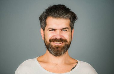 Mutlu adam gülen surat. Berber dükkanında uzun sakallı ve bıyıklı bir adam. Yakışıklı, gülümseyen genç adam. Olumlu insan yüz ifadeleri ve duyguları