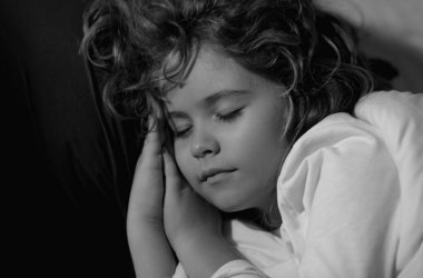 Sakin çocuklar uyur. Sevimli çocuk yatakta uyuyor. Uyuyan çocuk