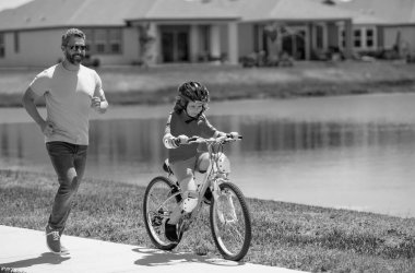 Babalar günün kutlu olsun. Baba oğul bisiklet sürmeyi öğreniyor ve Babalar Günü 'nde birlikte eğleniyorlar. Baba, Amerikan mahallesinde oğluna bisiklet sürmeyi öğretiyor. Baba oğul kavramı. Baba.