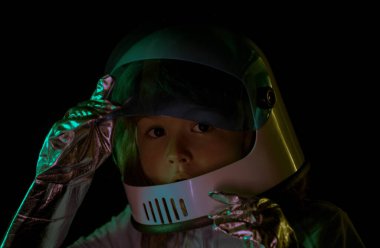 Uzay çocukları kozmonot konsepti. Mutluluktan kask takan küçük pozitif bir çocuğun portresi. Kopya alanı ile izole edilmiş arkaplan. Kapatın çocuklar yüzünü siyaha