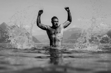 Çıplak kaslı İspanyol adam göle su sıçratıyor. Suyun içindeki çekici erkek seksi model. Yakışıklı çocuk Alps gölü suyunda dinleniyor. Suyun içinde çıplak, seksi bir adam. İnsan özgürlüğü yaşam tarzı. Güçlü kaslı adam.