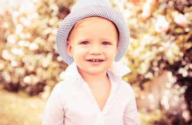 Bahar parkında küçük sevimli bir çocuğun portresi. Mutlu çocuk dışarıda eğleniyor.