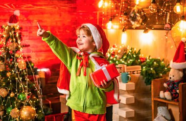 İçinde hediye kutusu olan mutlu küçük bir çocuk. Noel hediyesi tutan komik çocuk. Hediye duyguları. Mutlu çocuk Noel hediyesiyle