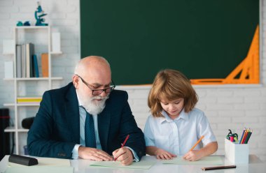 Okuldaki mutlu çocuk. Öğretmenin öğrenmesine yardım et. Eğitim, öğretmenlik, ilkokul.