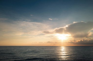 Gün batımı deniz manzarası. Gökyüzünde gün batımı ve renkli bulutlar. Sakin dalgalarla renkli sahil gündoğumu. Doğa deniz göğü. Mavi gökyüzüne ve denize karşı farklı renkte bulutlarla gün doğumu
