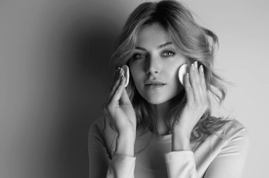 Beauty model cleansing her perfect skin by cotton pad sponge. Spa and wellness, skin care. Evening beauty routine. Beautiful woman cleaning her face with cotton pad. Skin treatment, cosmetology