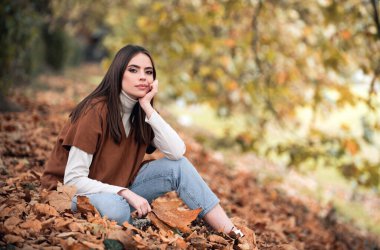 Sonbahar yapraklı genç bir kadının portresi. Romantik kız rüyası, sonbahar akçaağaç yapraklarını tut. Sonbahar mevsimi