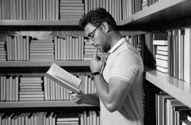 Sınıfta kitapla birlikte profesörün portresi. Kütüphanedeki yakışıklı profesör. Öğretmenler Günü. İyi bir profesör. Sınıfta kitap okuyan adam profesör. Bilgi eğitimi konsepti. Profesörler günü.
