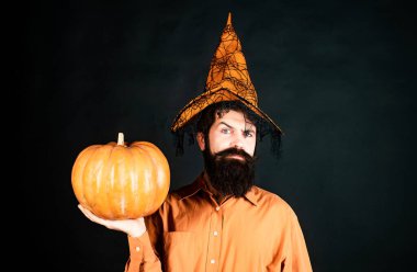 Cadılar Bayramı boncuklu adam balkabağı tutar - portre. Çılgın şakacı surat. Elinde balkabağı olan yakışıklı bir cadılar bayramı erkeği. Mutlu Cadılar Bayramı Hafta sonları