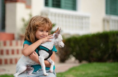 Yavru köpek kucaklaşması. Komik çocuk dışarıda köpekle oynuyor.