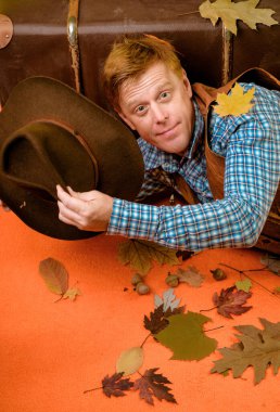 Kızıl saçlı adam turuncu bir arka plan üzerinde yatıyor. Kızıl saçlı adam sonbahar satış için hazır alıyorsanız