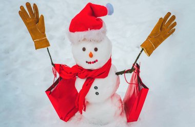 Satılık kardan adam. Kutlama Sanat Kutlama Kartı. Kar tarlasında şapkalı ve atkılı şirin bir kardan adam ve sürpriz bir Noel hediyesi. Mutlu Noeller ve fotokopi alanı olan mutlu yıllar.