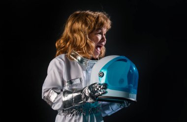 Kasklı, koruyucu uzay giysili, siyah giysili, şaşırmış küçük astronotun portresi.