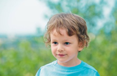 Gülümseyen ve eğlenen mutlu bir çocuğun portresi. Mutlu küçük çocuk. Şehir parkında yürüyüş yapan küçük bir çocuğun duygusal portresi. Yazın doğada mutlu bir çocuk. Çocuk dışarıda oynuyor.