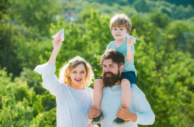 Retro hipster romantik çift mutlu çocuğa aşık. Hayal kurma özgürlüğü. Oyuncak uçakla oynayan neşeli çocuk. Gökyüzüne karşı. Çocukluk. Aile seyahati ve tatil konsepti