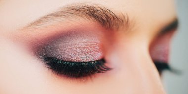 Güzel kadın yüzü. Makyaj modeli. Stüdyoda gri arka planda güzel bir genç kız