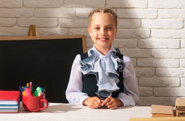 Okulda kitap okuyan mutlu liseli kız. Sınıftaki çocuklar okulda. Birinci sınıf.