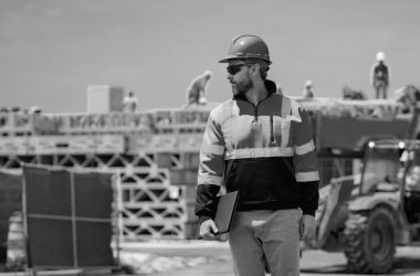 Yeni evde profesyonel inşaat işçisi. Dışarıdaki işçilerin portresi. İnşaat alanında kasklı inşaat işçisi. İnşaat üniformalı mühendis.