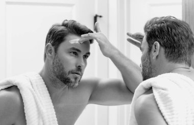 Erkek güzellik kozmetik ürünleri, güzellik ve cilt bakımı. Erkekler için sabah sağlık ve hijyeni. Mükemmel bir cilt. Duştan sonra yakışıklı adam cilt kremi ya da maske sür.