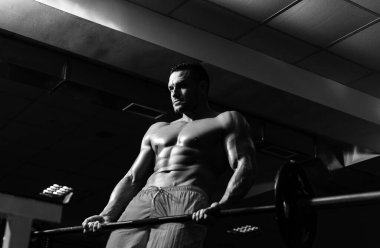 Spor salonunda güçlü bir vücut geliştirici. Antrenman ve idman. Antrenman egzersizleri. Çıplak gövdeli ve atletik vücutlu seksi sporcu.