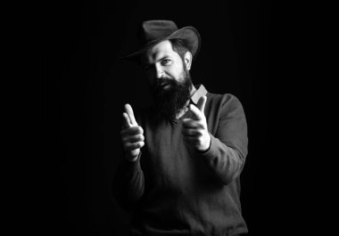 Kovboy parmakla işaret ediyor. Şerif ya da şerif. Kovboyla vahşi batı. Siyah üzerine tabanca taşıyan ciddi bir adam.