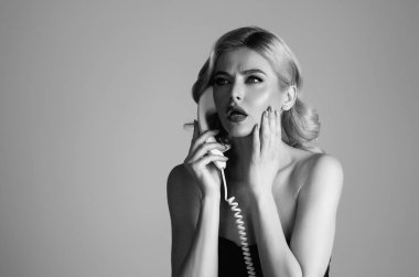 Şehvetli bir kadın eski telefon hattında konuşuyor, telefon çalıyor. Elinde antika telefon tutan kadın portresi. Telefon ahizeli kızı bağla. Eski model telefon ahizesi. Elinde telefon tüpü tutan kadın.