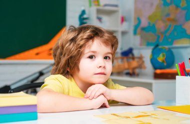 Derste mutlu okul çocukları. Sınıfta, tahtaya yakın arkadaş canlısı bir çocuk.