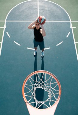 Basketbolcu açık sahada basket oynuyor. Şehir gençlik oyunu. Spor başarısı kavramı, puanlar ve galibiyet