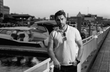 Şehir caddesinde yürüyen, faşist kıyafetli yakışıklı bir adam. Büyük şehirde başarılı bir erkek model şehir yaşamını sürdürüyor. Sokakta yürüyen genç erkek manken. Sokaktaki genç İspanyol adam.