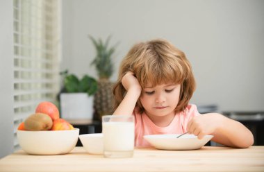 Bir tabak çorbası olan komik bir çocuk. Çocuk yemeği.