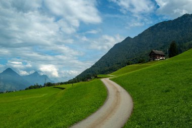 Yolculuk. Alplerdeki dağlardan geçen yol. İsviçre dağ manzarası. İsviçre 'de seyahat et. Alplerdeki köy yolu. Dağ yolu manzarası