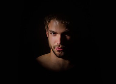 Moda erkek modeli. Üstsüz vücutlu yakışıklı bir adam. Kas modeli. Güçlü, vahşi adam. Yakışıklı spor modelinin portresi. Stüdyoda çıplak vücut pozu veren yakışıklı bir genç. Seksi erkek model.