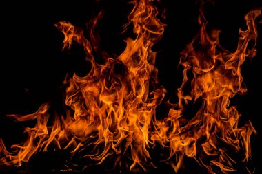 Siyah arka planda yangın alevleri. Ateş, izole edilmiş, soyut bir yapı. Yanma efektiyle yanan bir patlama. Duvar kağıdını ateşle, soyut sanat kalıpları
